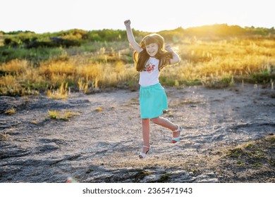 Jumping in happiness. A young red-headed girl jumping. - Shutterstock ID 2365471943