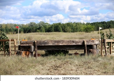Jumping Horse Log Obstacle On Cross Country Course Without Riders As A Background

