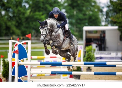 Jumping horse with rider over the jump from the front. - Shutterstock ID 2254279917