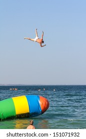 Jumping With Inflatable Water Catapult Balloon On The Sea Shore