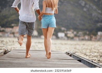 jumping with joy. Happy Couple holding hands and run to jump in the water - Powered by Shutterstock