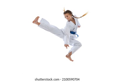 Jumping kick. Portrait of young girl, teen, taekwondo athlete practicing alone isolated over white background. Concept of sport, education, skills, workout, healthy lifestyle and ad. Power and energy. - Powered by Shutterstock