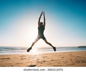 Jumping Man. Young Fitness Man Doing Jumping Jacks Or Star Jump Exercise On The Beach