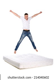 Jumping on the mattress. Young man jumping on the mattress, isolated on white background