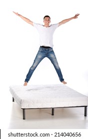 Jumping on the mattress. Young man jumping on the mattress, isolated on white background