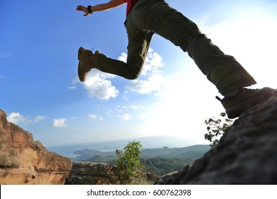 jumping over precipice between two rocky mountains. freedom, risk, challenge, success concept