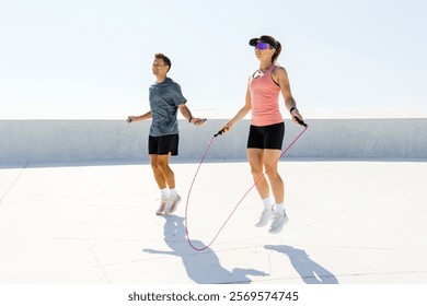 Jumping rope on a sunny rooftop, enjoying outdoor fitness and exercising together in the morning - Powered by Shutterstock