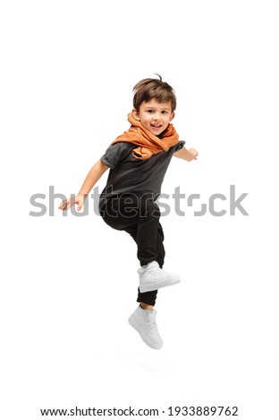 Jumping, running. Happy, smiley little caucasian boy isolated on white studio background with copyspace for ad. Looks happy, cheerful. Childhood, education, human emotions, facial expression concept.