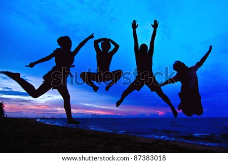 jumping team at sunset time as silouette background