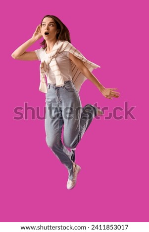 Jumping young gossip woman trying to hear something on purple background