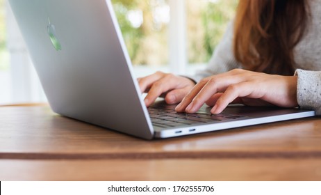 Jun 16th 2020 : A Woman Using And Typing On Apple MacBook Pro Laptop Computer On Wooden Table , Chiang Mai Thailand