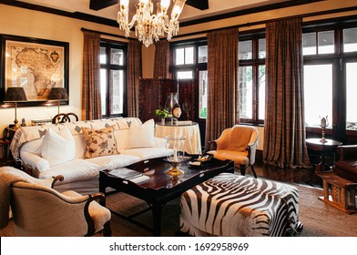 JUN 19, 2011 Serengeti, Tanzania - Luxury African Safari Lodge Living Room  Interior With Old Vintage Armchairs And Sofa Couch Antique Furniture Decoration Under Warm Light