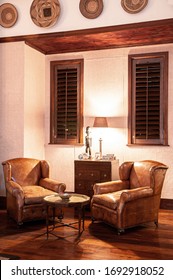 JUN 20, 2011 Serengeti, Tanzania - Luxury African Safari Lodge Interior With Old Vintage Leather Armchairs Wooden Table Under Warm Light And Antique Decoration