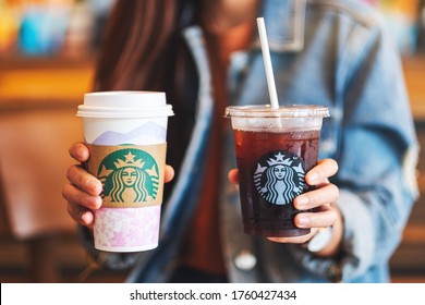 Jun 20th 2020 : Close up of a woman holding iced coffee and hot coffee at Starbucks coffee shop , Chiang mai Thailand 
