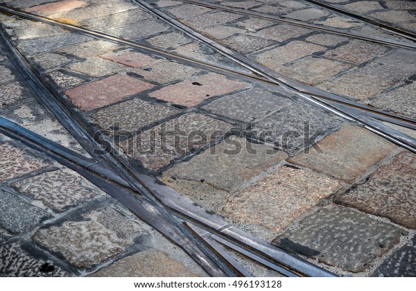 Junction of tramway (trolley car, cable car) rails\
with paving tiles