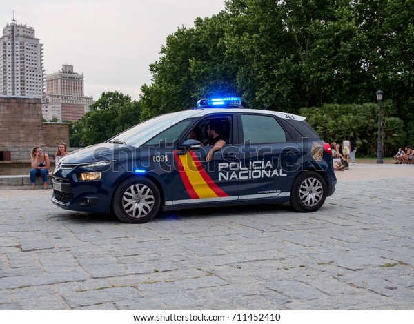 June 20, 2017. Policemen\
patrol Parque del Oeste in a cruiser vehicle with the emergency\
lights turned on. Madrid, Spain. Travel and security editorial\
concept.