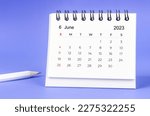 June 2023 Monthly desk calendar for 2023 year with pencil on purple background.