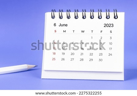 June 2023 Monthly desk calendar for 2023 year with pencil on purple background.