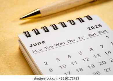 June 2025 - small spiral desktop calendar, time and business concept