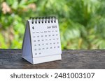 June 2025 white table calendar with outdoor background. Calendar concept.