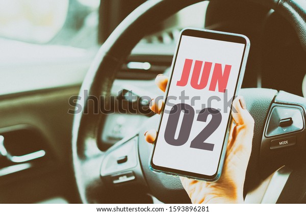 june\
2nd. Day 2 of month,Calendar date. Month and day placed on a\
smartphone screen in womans hand in car interior. artistic\
coloring.  summer month, day of the year\
concept