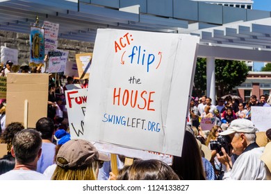 June 30, 2018 San Jose / CA / USA - Voting message "Act Flip the House" raised at the "Families belong together" rally held in front of the City Hall, in downtown San Jose