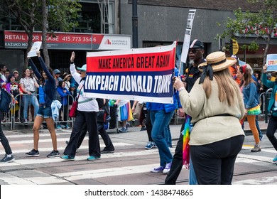 June 30, 2019 San Francisco / CA / USA - Participants at the 2019 San Francisco Pride Parade carrying a sign with a political message stating Make America Great Again / Impeach Donald Trump