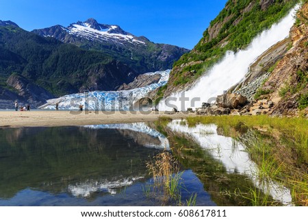 Juneau, Alaska. Mendenhall Glacier Viewpoint with reflection in the lake and waterfall.