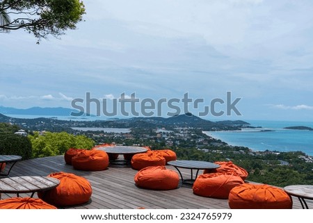 The jungle club samui ,Orange beanbag place to relax Sea view Chaweng beach in Koh Samui, Thailand. The scenery of seascape and bay with city and forest of coconut trees beautiful blue sky