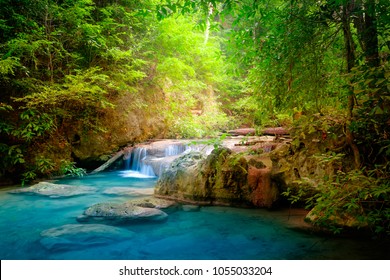 Jungle landscape with flowing turquoise water of Erawan cascade waterfall at deep tropical rain forest.Park Kanchanaburi, Thailand