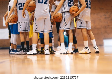 Junior Basketball Team During Training Class Standing Together and Huddling in Circle. Players Listening to Coaches' Motivational Speech Before The Game. Men's College Basketball Team at Tournament - Powered by Shutterstock