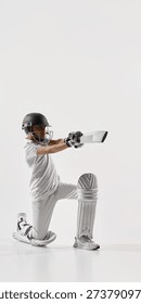 Junior cricket player kneeling while playing defensive shot isolated on white. Concept of cricket coaching materials, youth sports advertising, action pose cutout for design and editorial layouts.