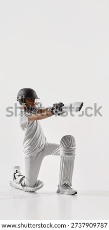 Junior cricket player kneeling while playing defensive shot isolated on white. Concept of cricket coaching materials, youth sports advertising, action pose cutout for design and editorial layouts.
