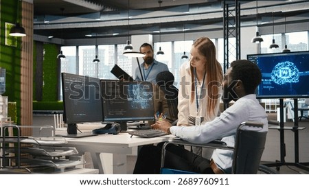 Junior dev and coworker in wheelchair developing software applications, optimizing code. Female technician and colleague with paraplegia in office using AI to solve bottlenecks, camera A