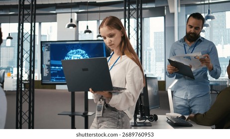 Junior developer utilizing artificial intelligence to optimize performance and forecast issues. Young female engineer in office training machine learning models, camera A
