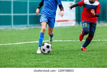 Junior Football Match. Soccer Game For Youth Players. Boys Playing Soccer Match on Football Pitch. Football Stadium and Grassy Field in the Background - Powered by Shutterstock