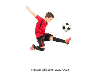 Junior football player kicking a ball isolated on white background