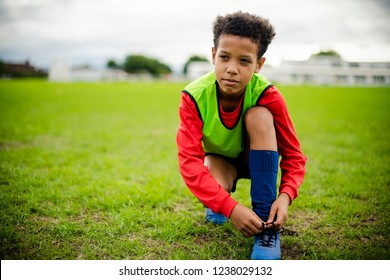 Junior football player tying his shoelaces - Powered by Shutterstock