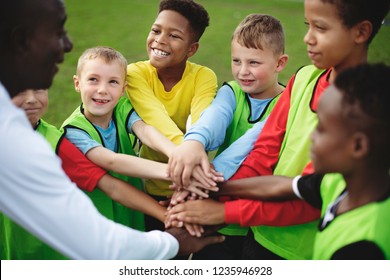 Junior football team stacking hands before a match