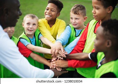 Junior football team stacking hands before a match