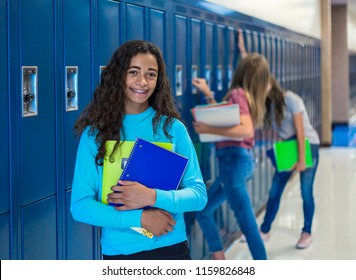 Junior High school Student smiling in a school hallway. Black Female school girl smiling and having fun together during a break at school standing by her locker
