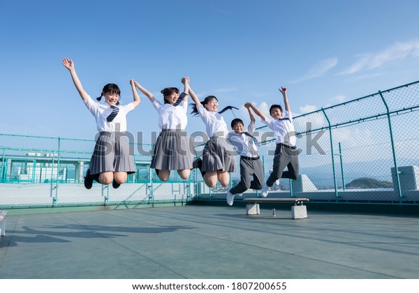 Junior high\
school students jumping on the\
roof