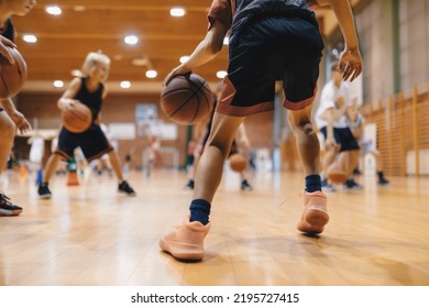 Junior level basketball player bouncing basketball. Young basketball player with classic ball. Basketball training session for youth. School sports class - Shutterstock ID 2195727415