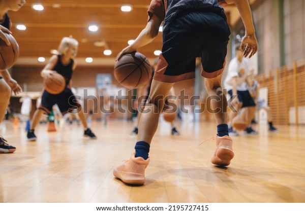 Junior level basketball player\
bouncing basketball. Young basketball player with classic ball.\
Basketball training session for youth. School sports\
class