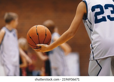 Junior level basketball player holding game ball at practice drill. Basketball training session for kids - Powered by Shutterstock