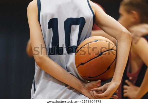 Junior level basketball player holding\
game ball. Basketball training session for\
kids
