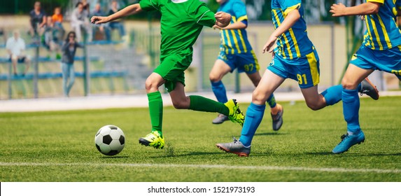 Junior Level Football Competition. School Soccer Tournamrnt. Group Of Boy Running After Ball On Rummer Day