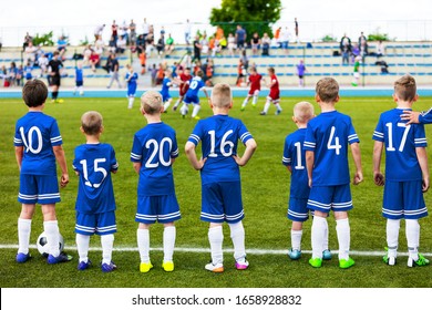 Junior Level Kids Sports Team. Football Soccer Children Players Standing Together with Coach During School Soccer Competition Game. Boys in Blue Soccer Jersey Sportswear and Soccer Cleats - Powered by Shutterstock