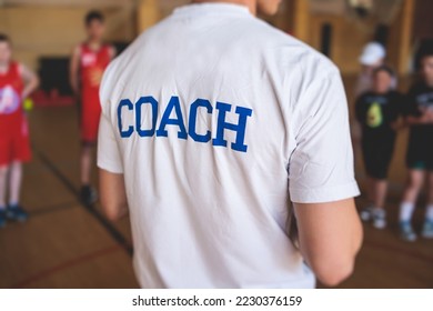 Junior young basketball team with a coach, group of kids children team having training and team talk speach with trainer instructor, basket coach explaining the game plan tactics on a court - Powered by Shutterstock