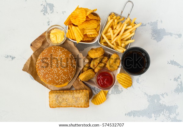 Junk food on table. Fast\
carbohydrates not good for health, heart and skin. Space for\
text